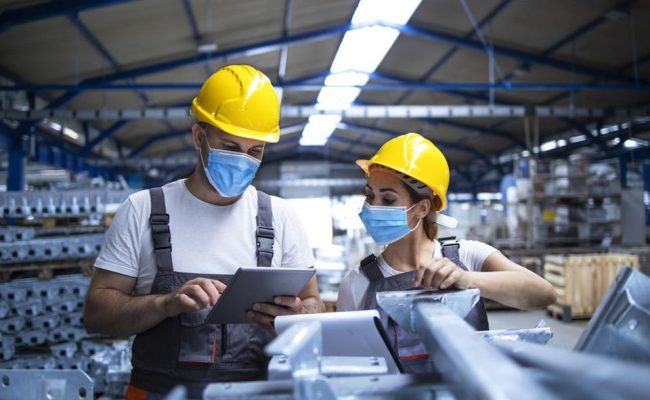 https___specials-images.forbesimg.com_imageserve_603421b82ab5cedc6a9a99a1_Industrial-workers-with-face-masks-protected-against-corona-virus-discussing-about_960x0